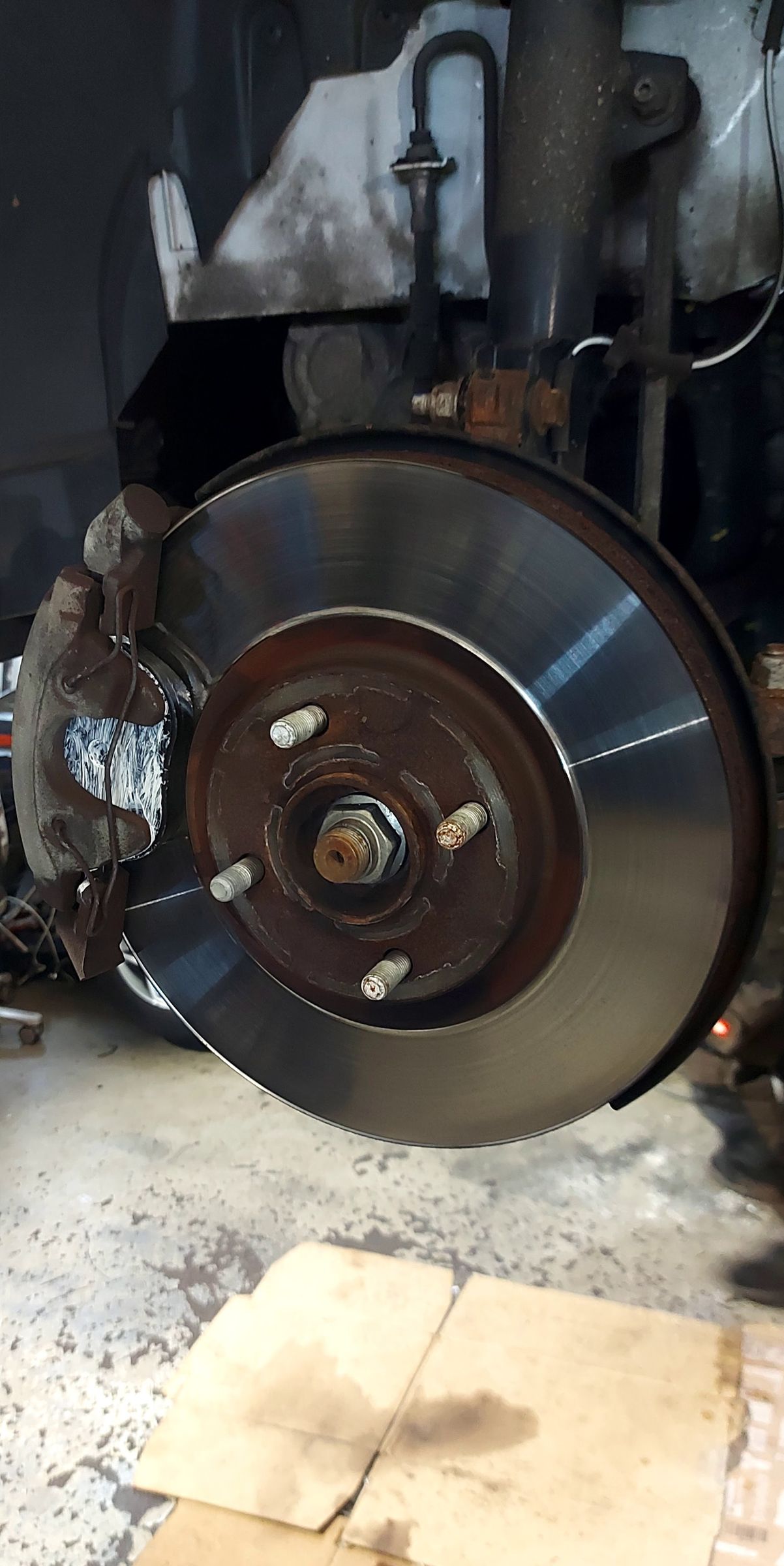 Neue Bremsscheibe an einem angehobenen Fahrzeug